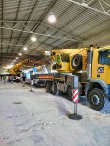 Gru camion gialli in un capannone industriale.