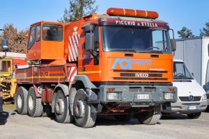 Camion arancione per soccorso stradale parcheggiato all'aperto.