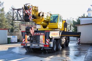 Camion gru giallo parcheggiato in un'area industriale.